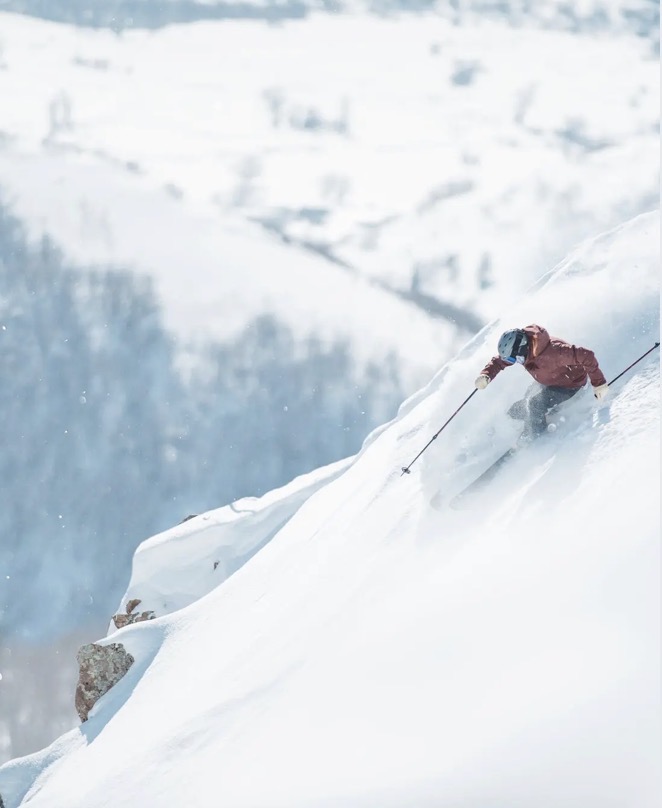 Skier carving through deep powder above Deer Valley